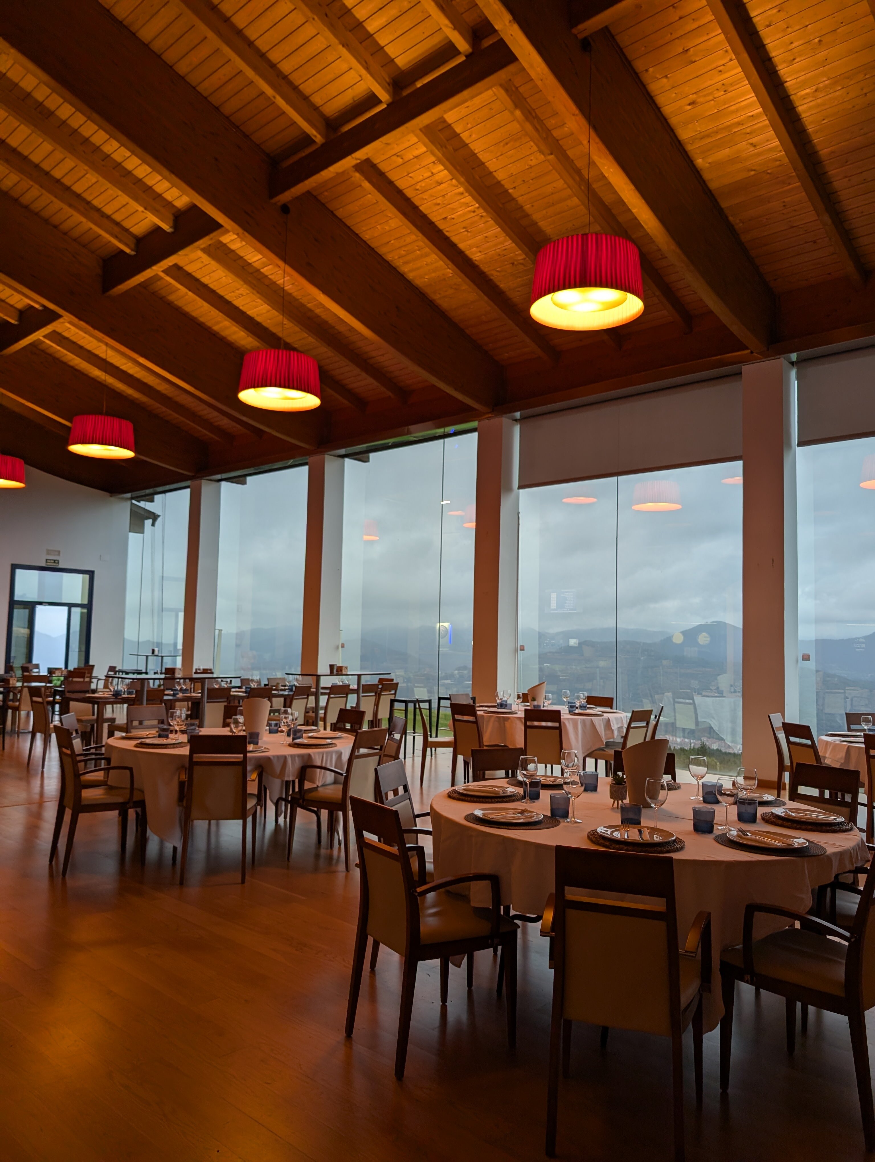Interior del restaurante con techos altos de madera y ventanales